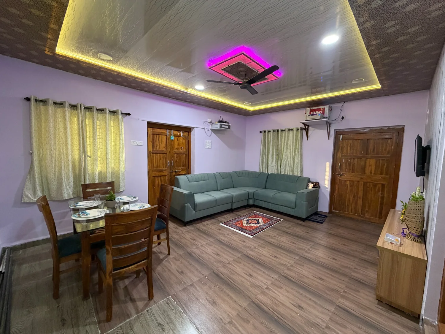 Living room with sofa, dining area, TV and ambient lighting