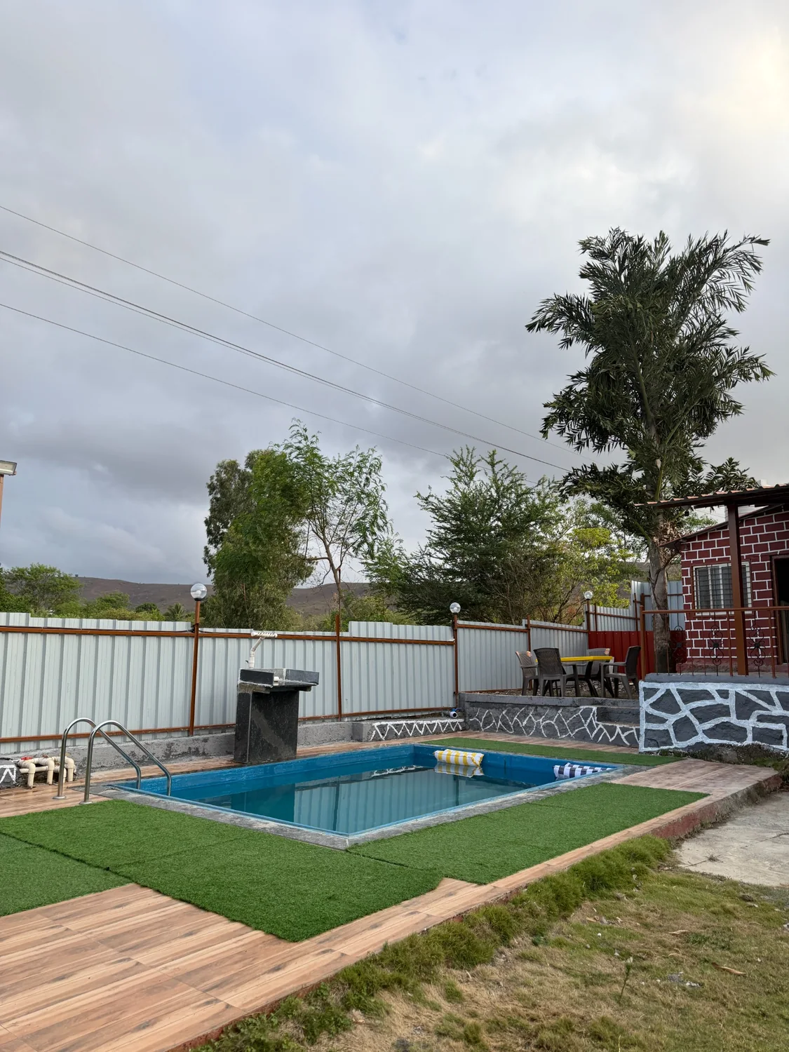 Swimming pool with lawn and villa backdrop